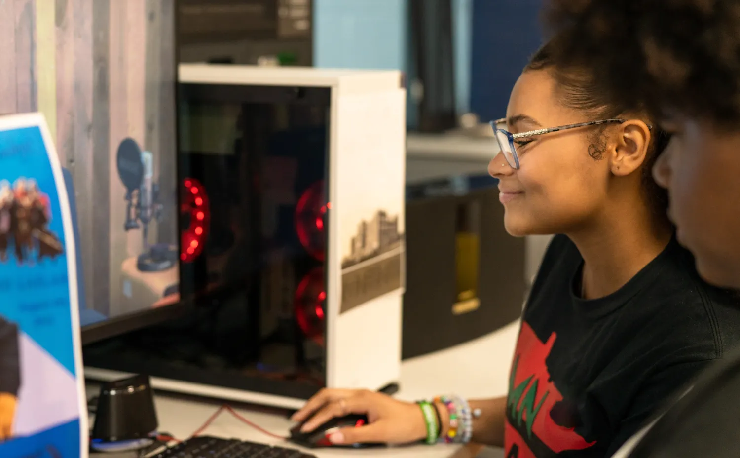 A young woman is using a desktop computer.