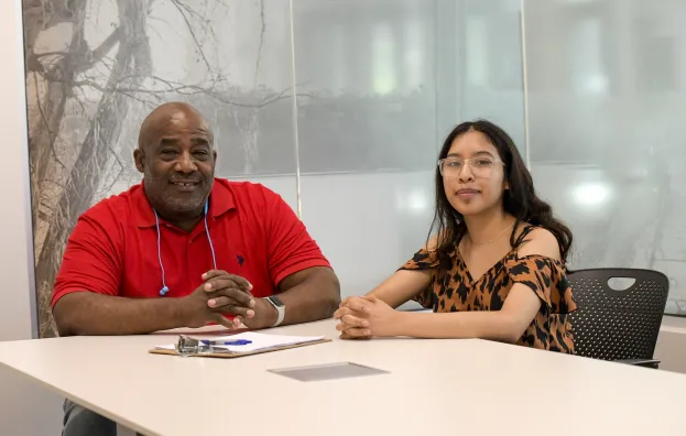 Xcel Energy supervisor with Step Up intern sitting at desk