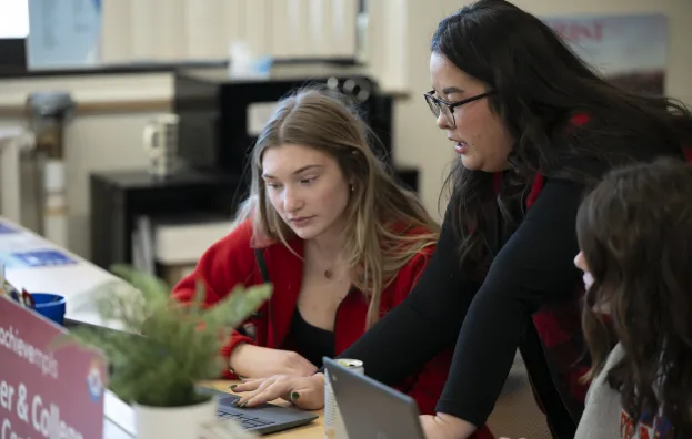 Achieve staff member talking with student in high school