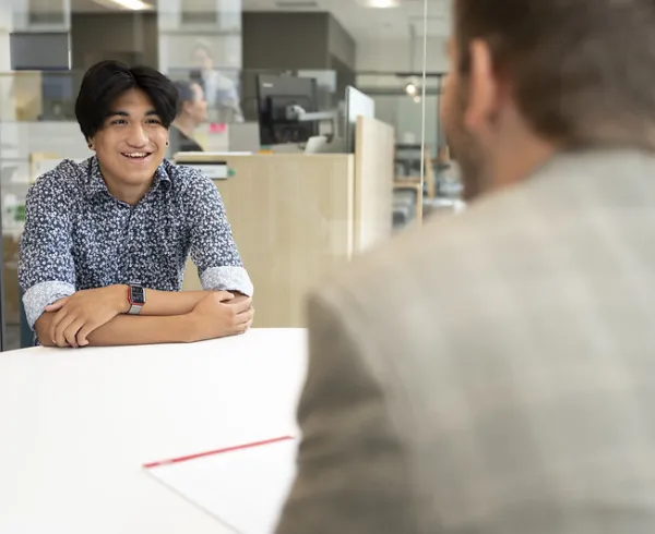 Adult and student sitting across from each other at an office table