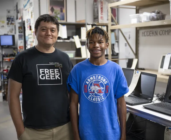 Intern and supervisor standing side by side smiling for the camera