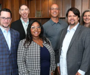 Six Achieve Twin Cities board members standing in meeting room 