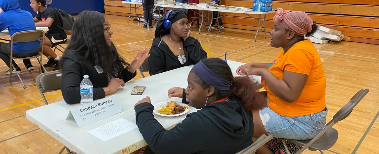 teacher talking with students in gym