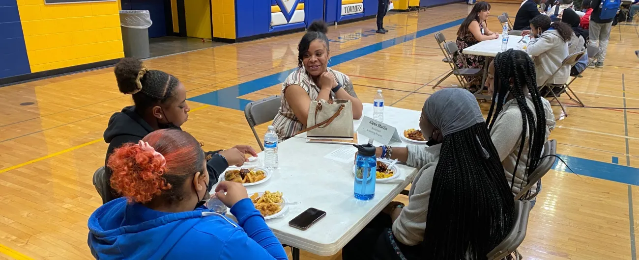 Accountant talking with students in a school gym