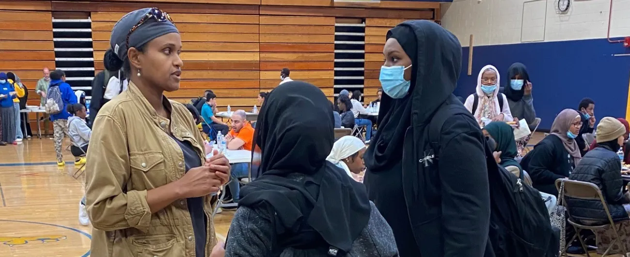 Dentist talking with two students in a school gym