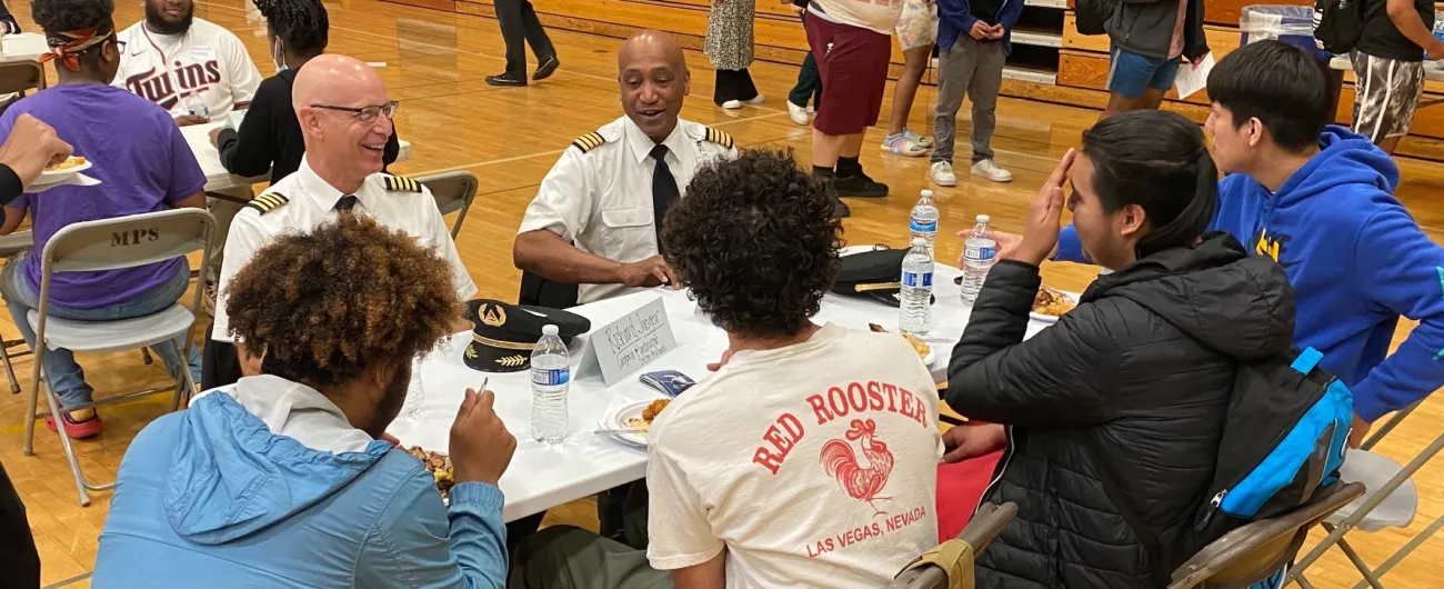 Two pilots talking with a group of students