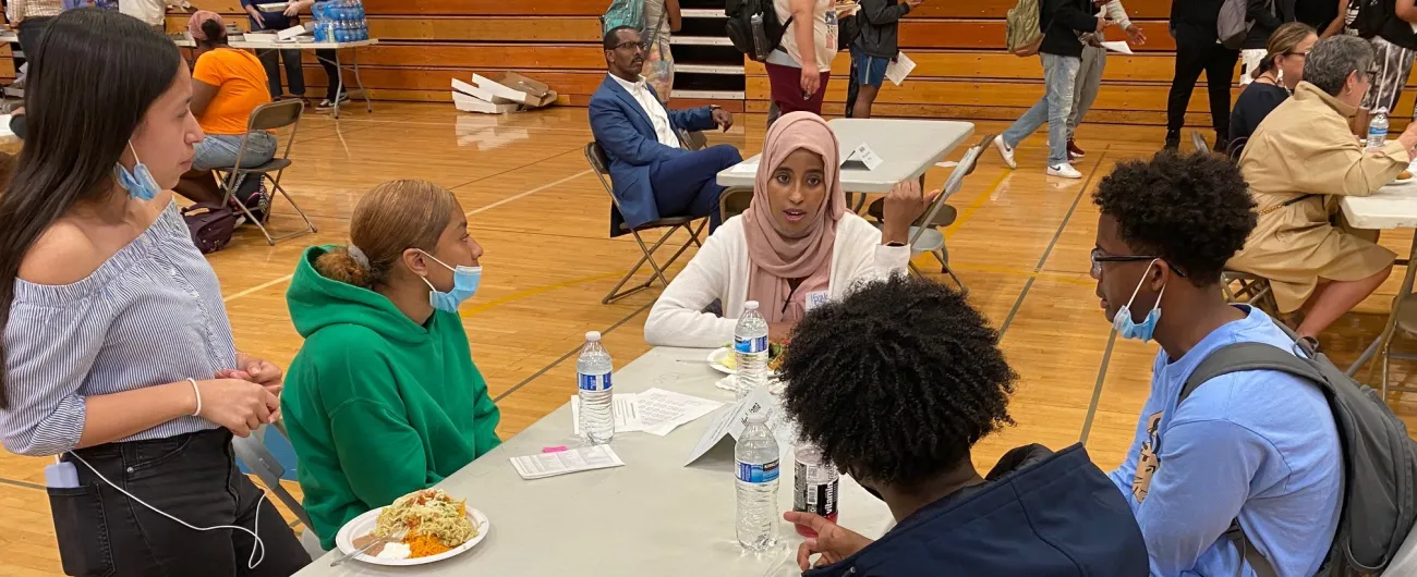 Volunteer talking with students in school gym