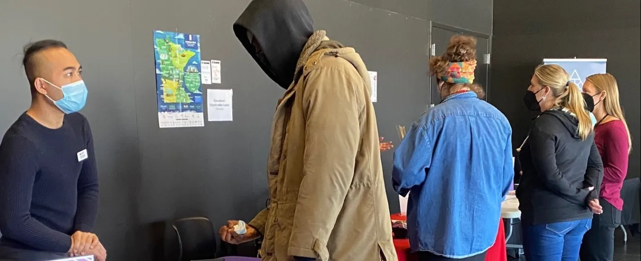 People standing at tables looking at materials 