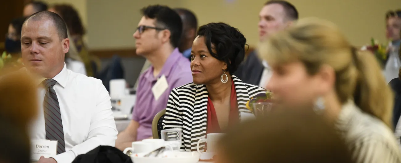 Crowd of people at a dinner listening to speaker