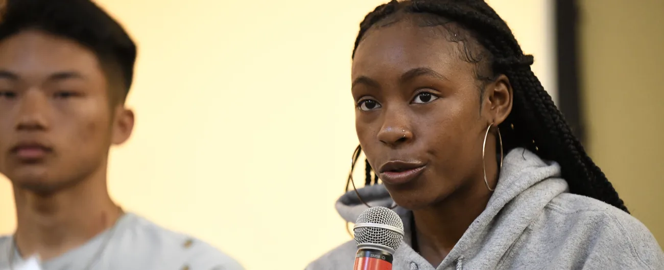 Student with microphone speaking to a crowd