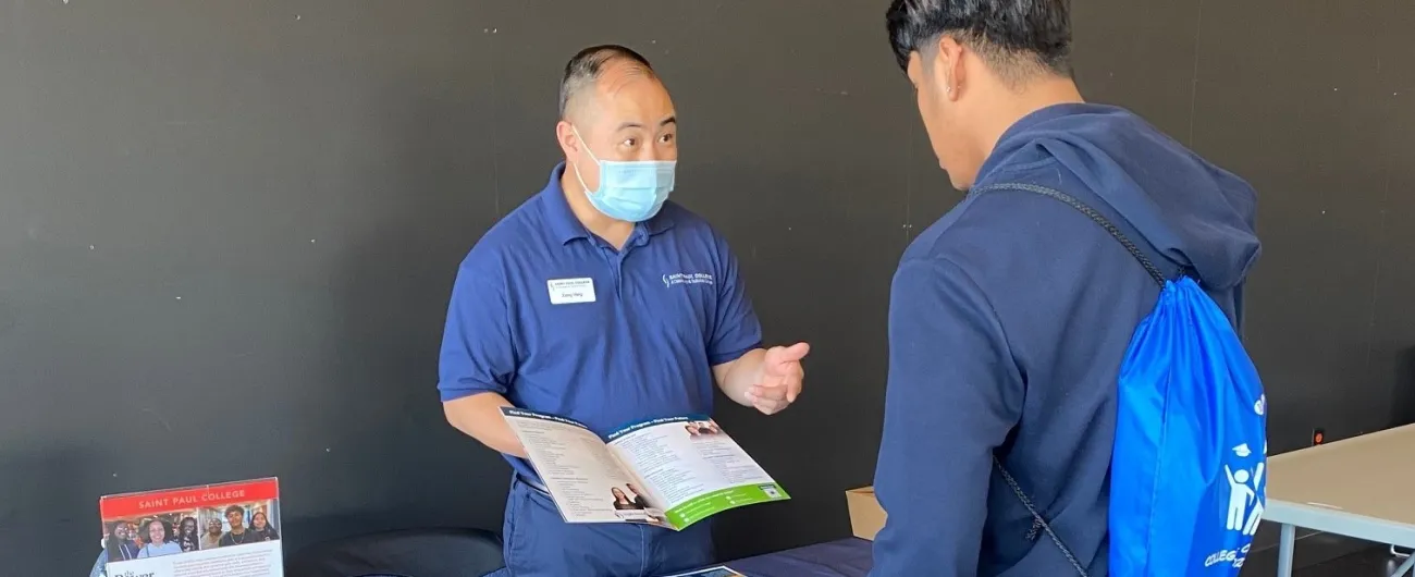 Two men at table talking about brochure