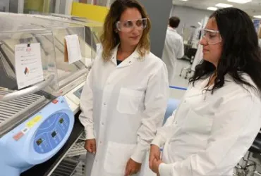 Two people operating hospital equipment.